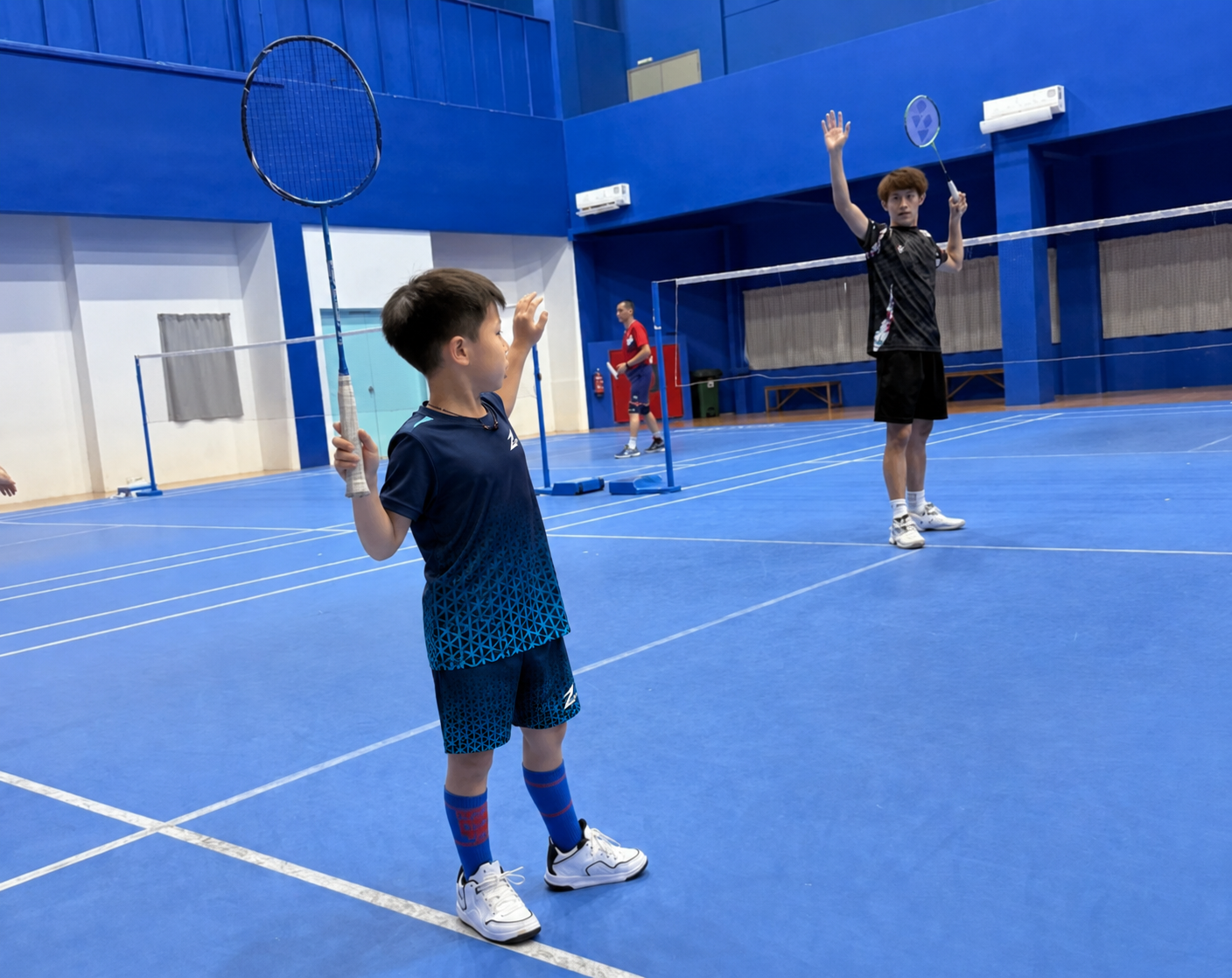Child training badminton on court